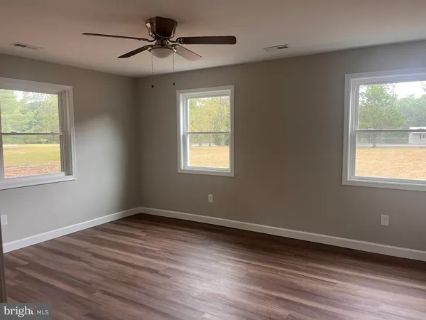 a view of a room with wooden floor and a window