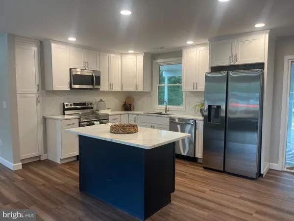 a kitchen with kitchen island a sink appliances and cabinets