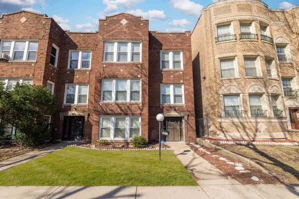 a view of a brick building next to a yard