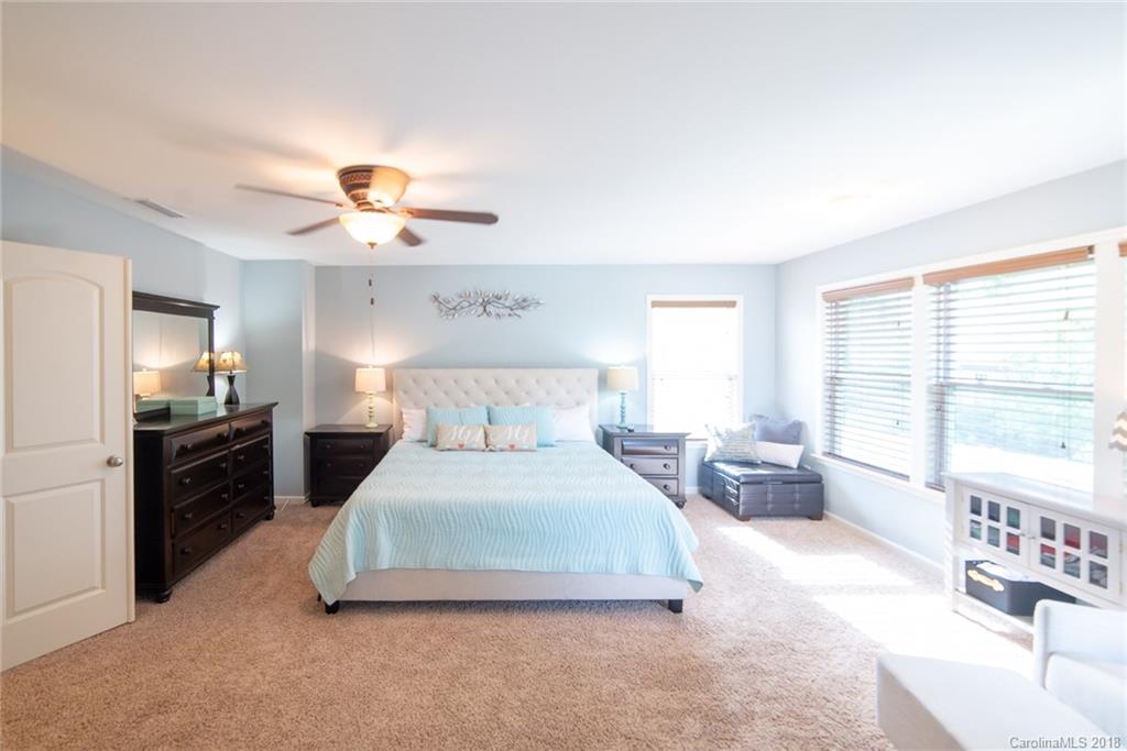 7196 Meyer Road Fort Mill, SC 29715 - Photo 23 of 31 a bedroom with a bed and a chandelier