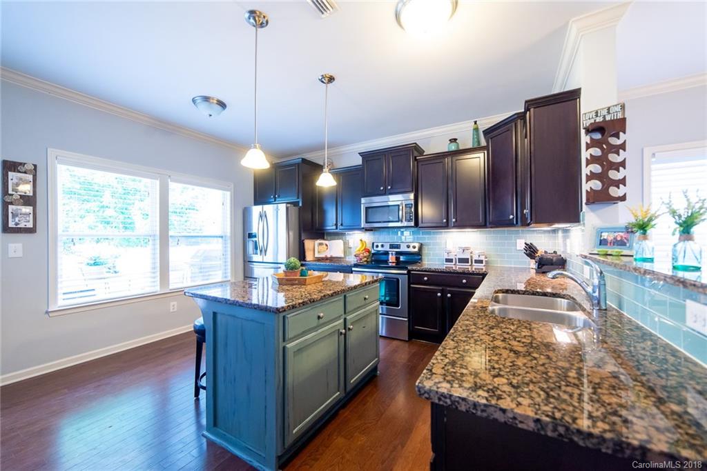 7196 Meyer Road Fort Mill, SC 29715 - Photo 9 of 31 a kitchen with granite countertop wooden cabinets and a stove