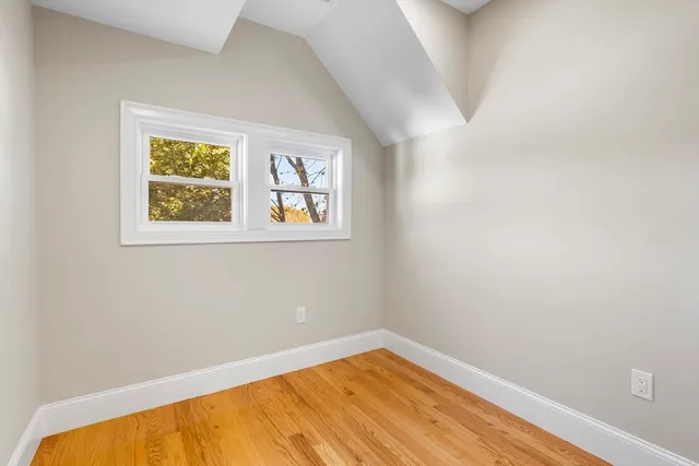 a view of a room with wooden floor and a window