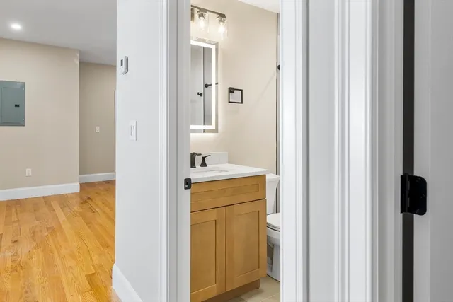 a bathroom with a sink and mirror with toilet
