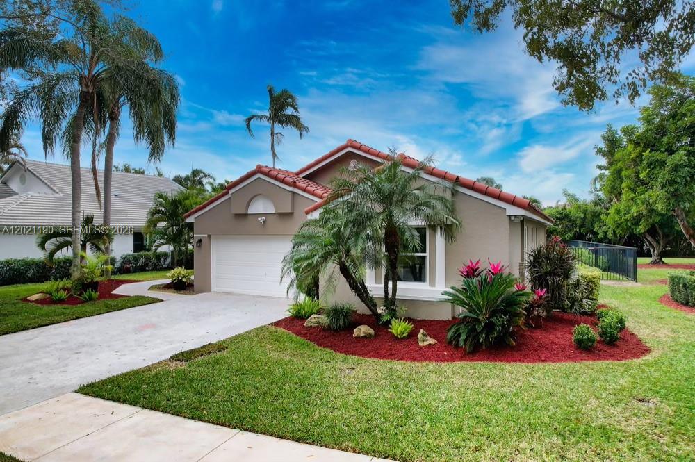 814 Heron Road Weston, FL 33326 - Photo 5 of 27 a front view of a house with a garden