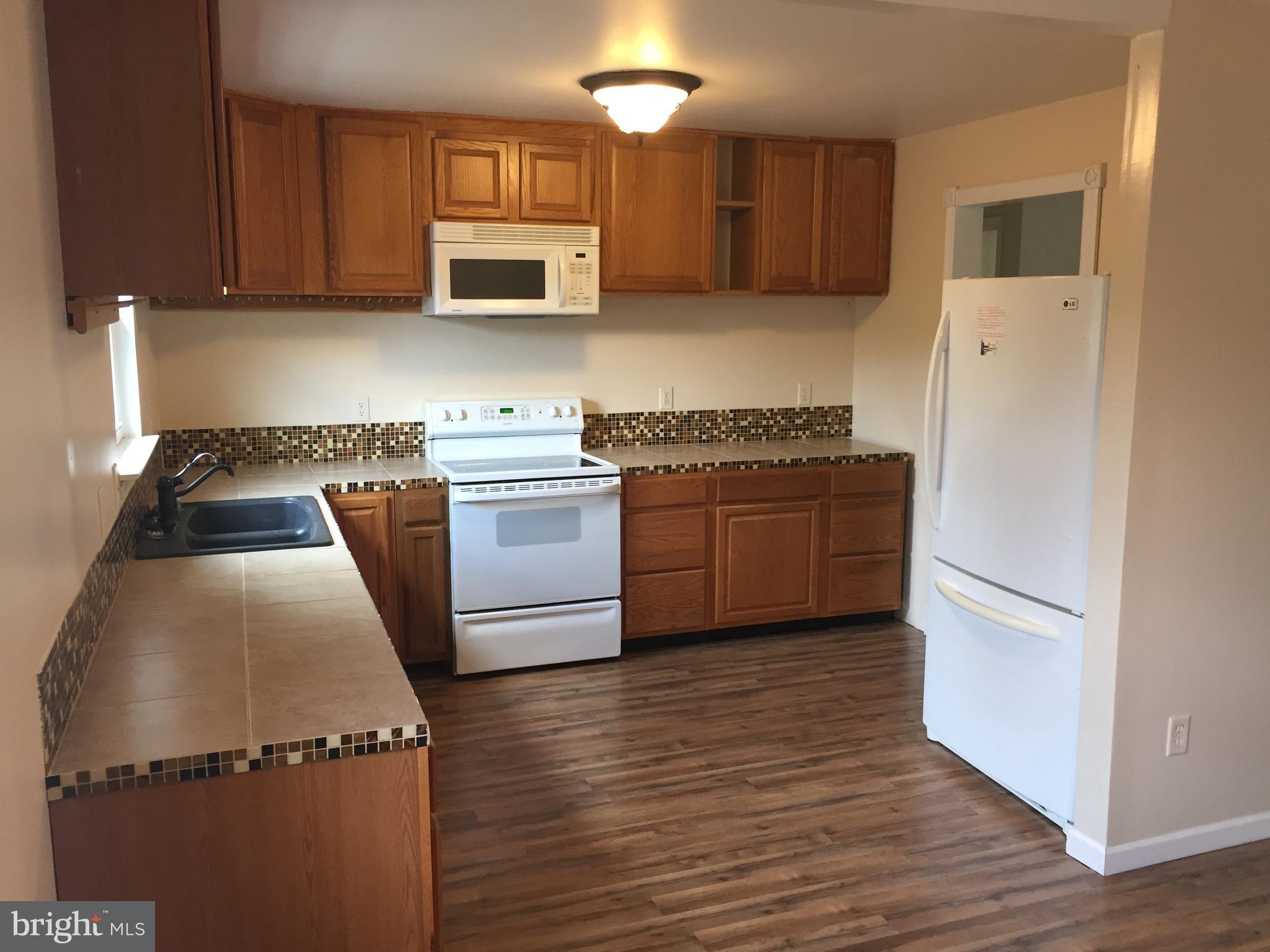 1329 Willow Spring Road Baltimore, MD 21228 - Photo 4 of 24 a kitchen with cabinets and a stove