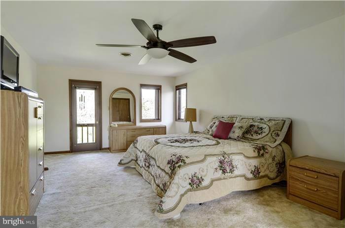 14900 Mount Nebo Road Poolesville, MD 20837 - Photo 14 of 30 a spacious bedroom with a bed a ceiling fan and a window