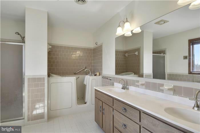 14900 Mount Nebo Road Poolesville, MD 20837 - Photo 15 of 30 a bathroom with a sink a toilet and a large mirror