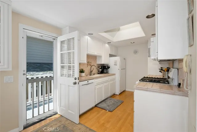 a kitchen with white cabinets and appliances
