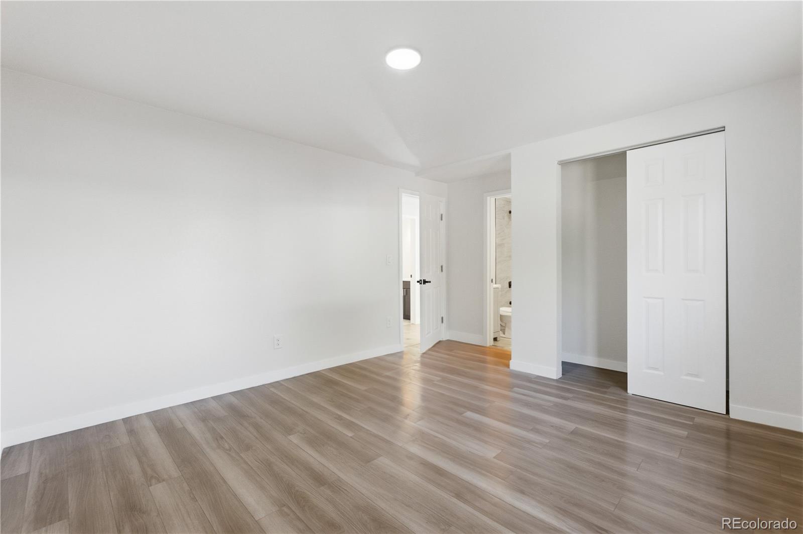 1550 South Xavier Street Denver, CO 80219 - Photo 13 of 46 a view of an empty room with wooden floor