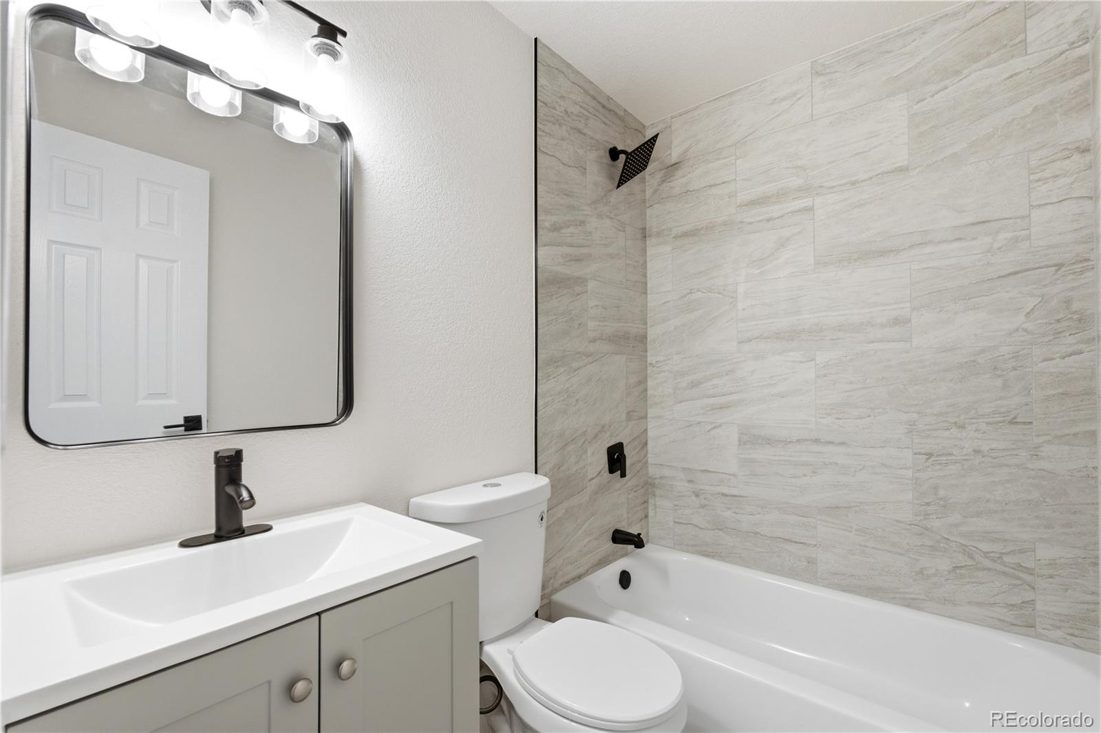 1550 South Xavier Street Denver, CO 80219 - Photo 14 of 46 a bathroom with a sink toilet vanity and shower