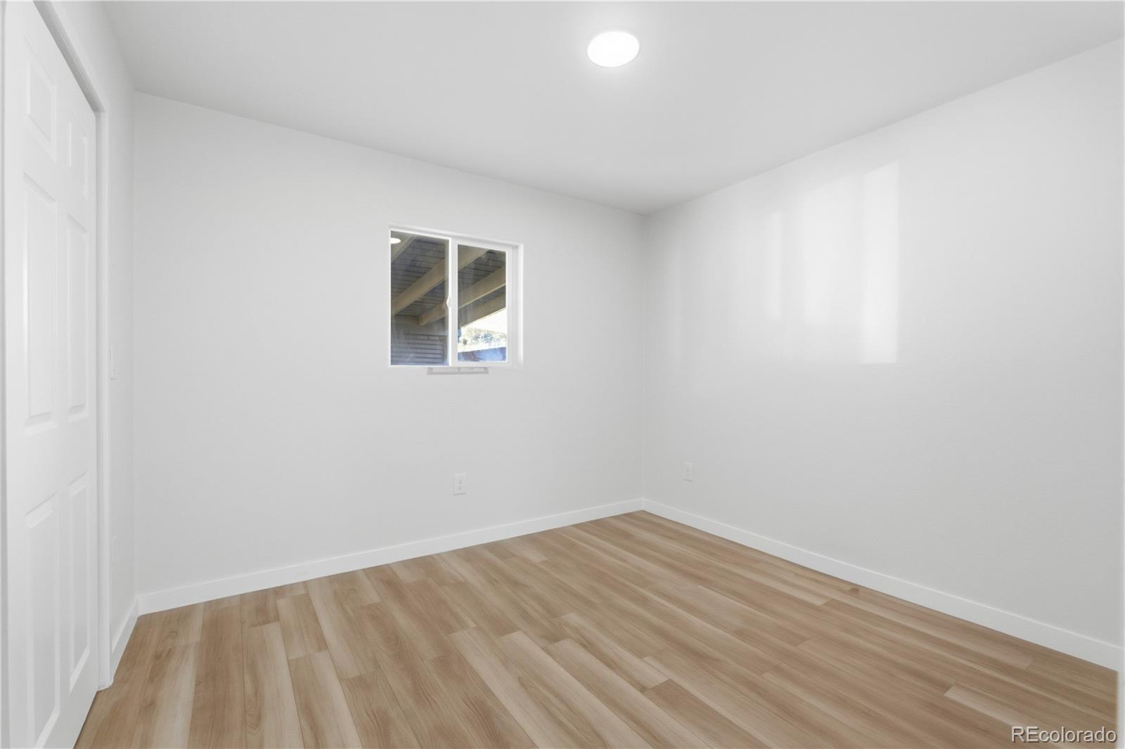 1550 South Xavier Street Denver, CO 80219 - Photo 18 of 46 a view of empty room with wooden floor and fan