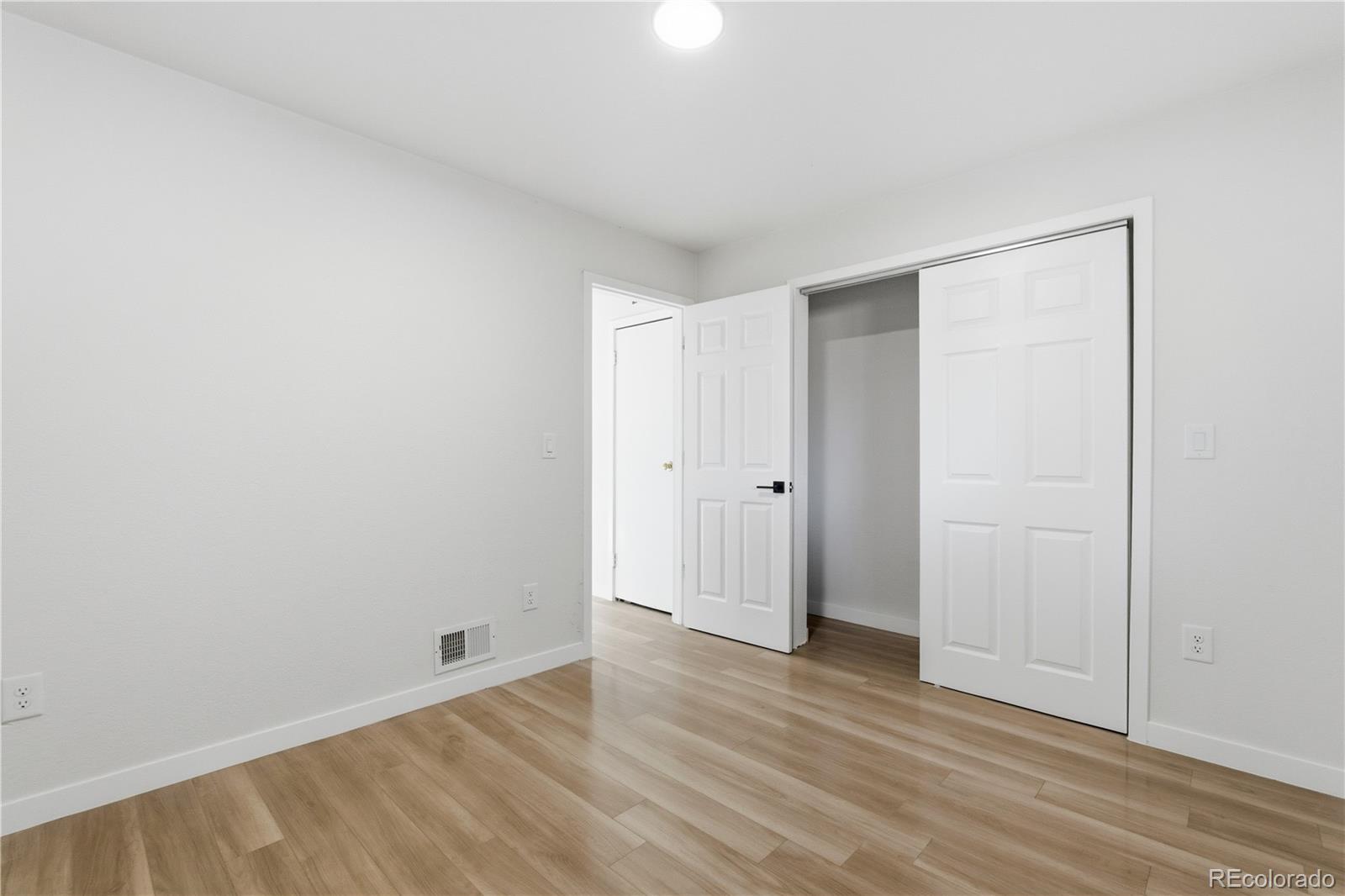 1550 South Xavier Street Denver, CO 80219 - Photo 19 of 46 a view of an empty room with wooden floor