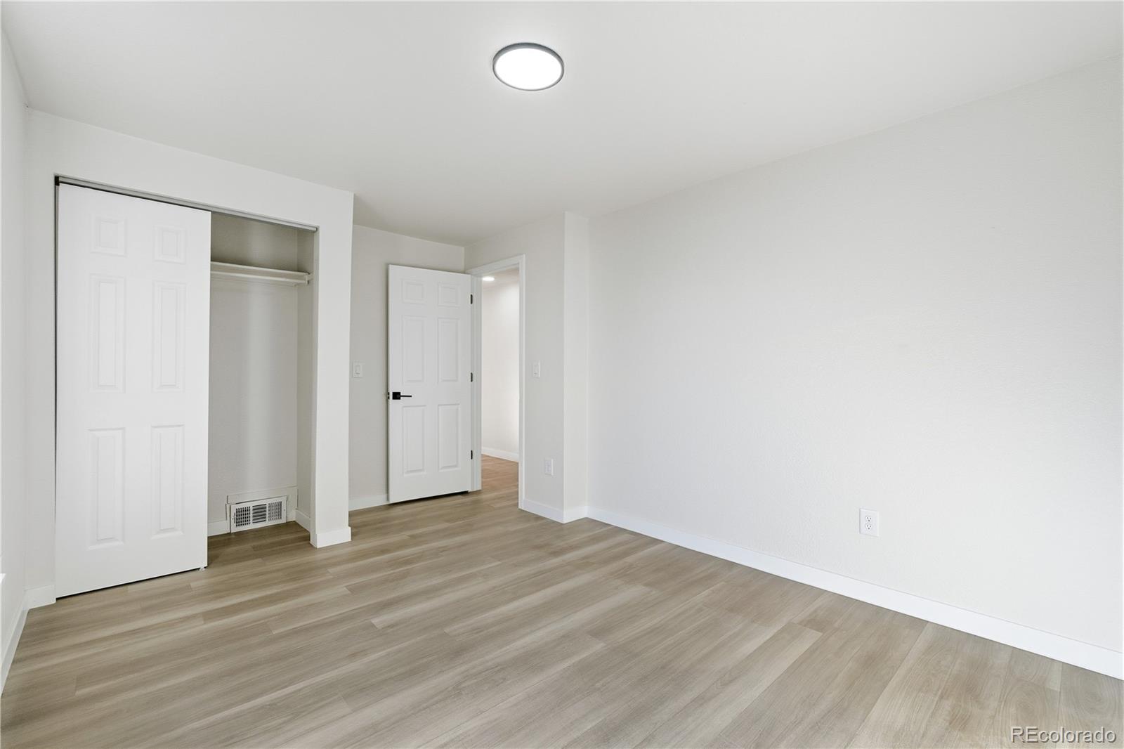 1550 South Xavier Street Denver, CO 80219 - Photo 9 of 46 an empty room with wooden floor and windows