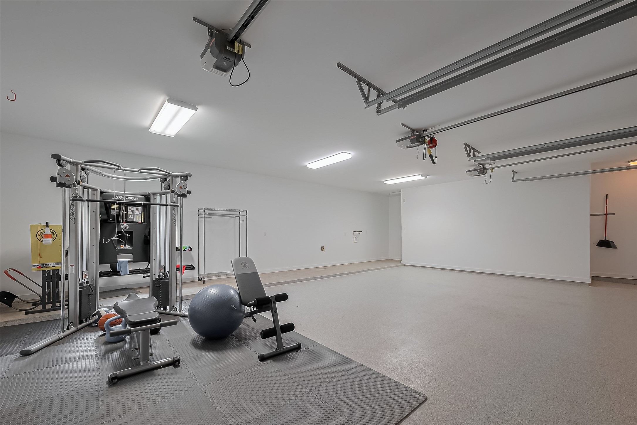 118 Angel Leaf Road The Woodlands, TX 77380 - Photo 41 of 50 Spacious 3-car garage currently used as a home gym with clean flooring and overhead storage.