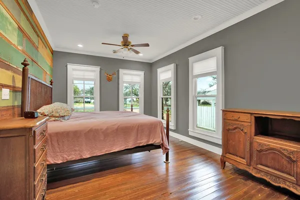 a bedroom with a bed dresser and a large window