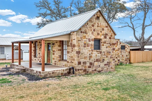 a view of a house with large windows and a small yard
