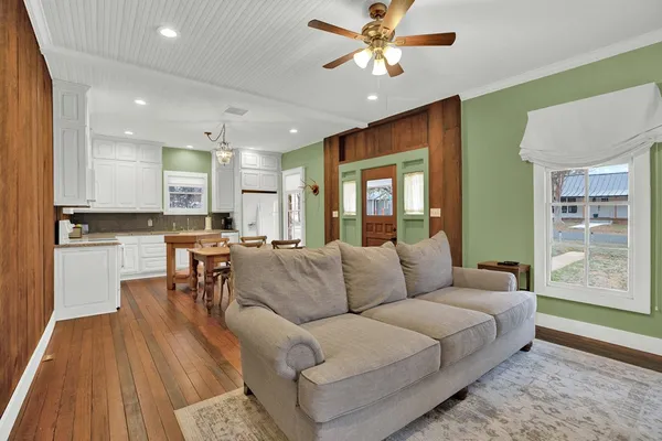 a living room with furniture and a view of kitchen