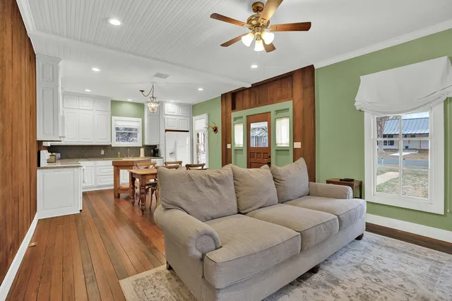 a living room with furniture and a view of kitchen