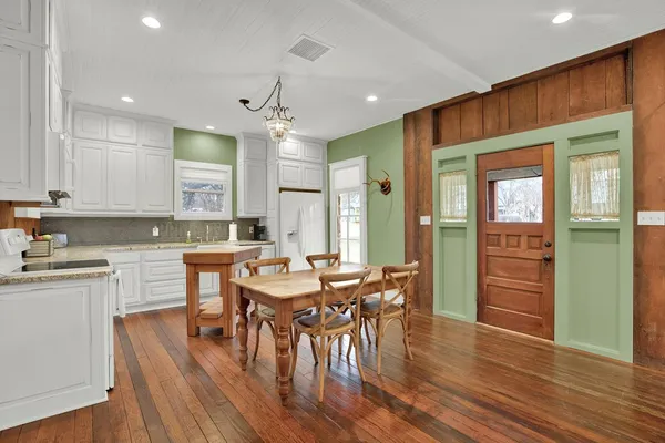 an open kitchen with wooden floor and stainless steel appliances
