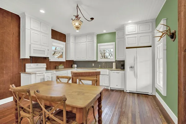 a kitchen with a table chairs refrigerator and microwave