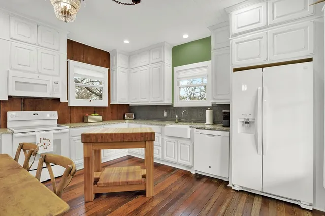 a kitchen with a refrigerator and white cabinets