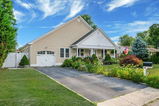 a front view of a house with a garden and yard