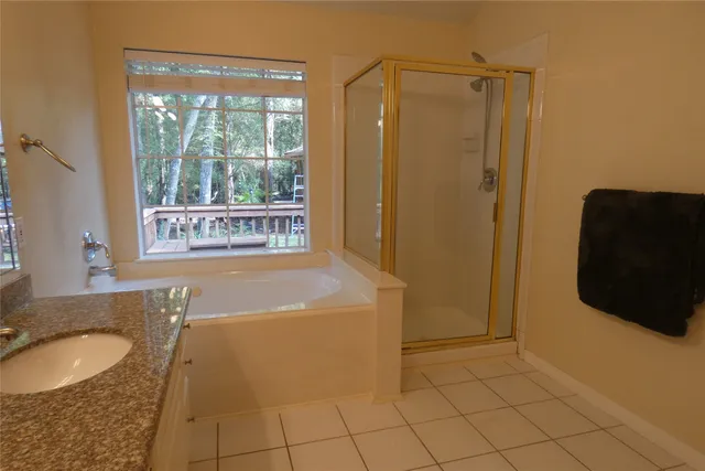 a bathroom with a granite countertop sink a mirror and a bathtub