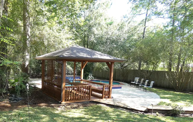 a view of a swimming pool with a patio and a yard
