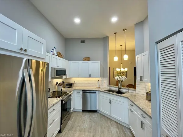 a kitchen with stainless steel appliances a refrigerator sink and cabinets