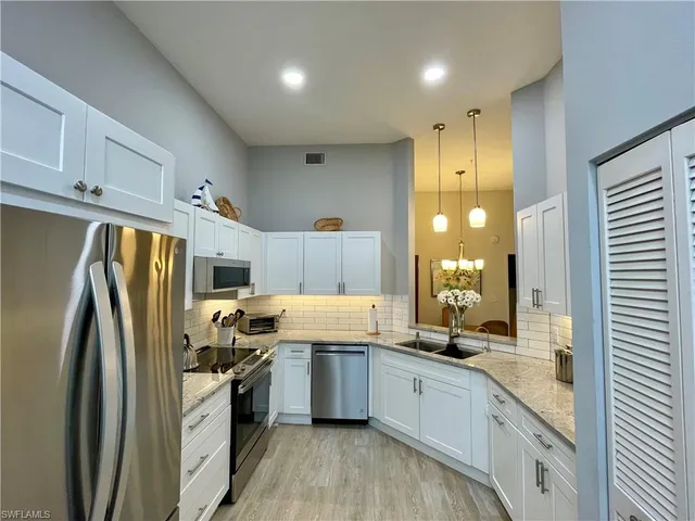a kitchen with stainless steel appliances a refrigerator sink and cabinets