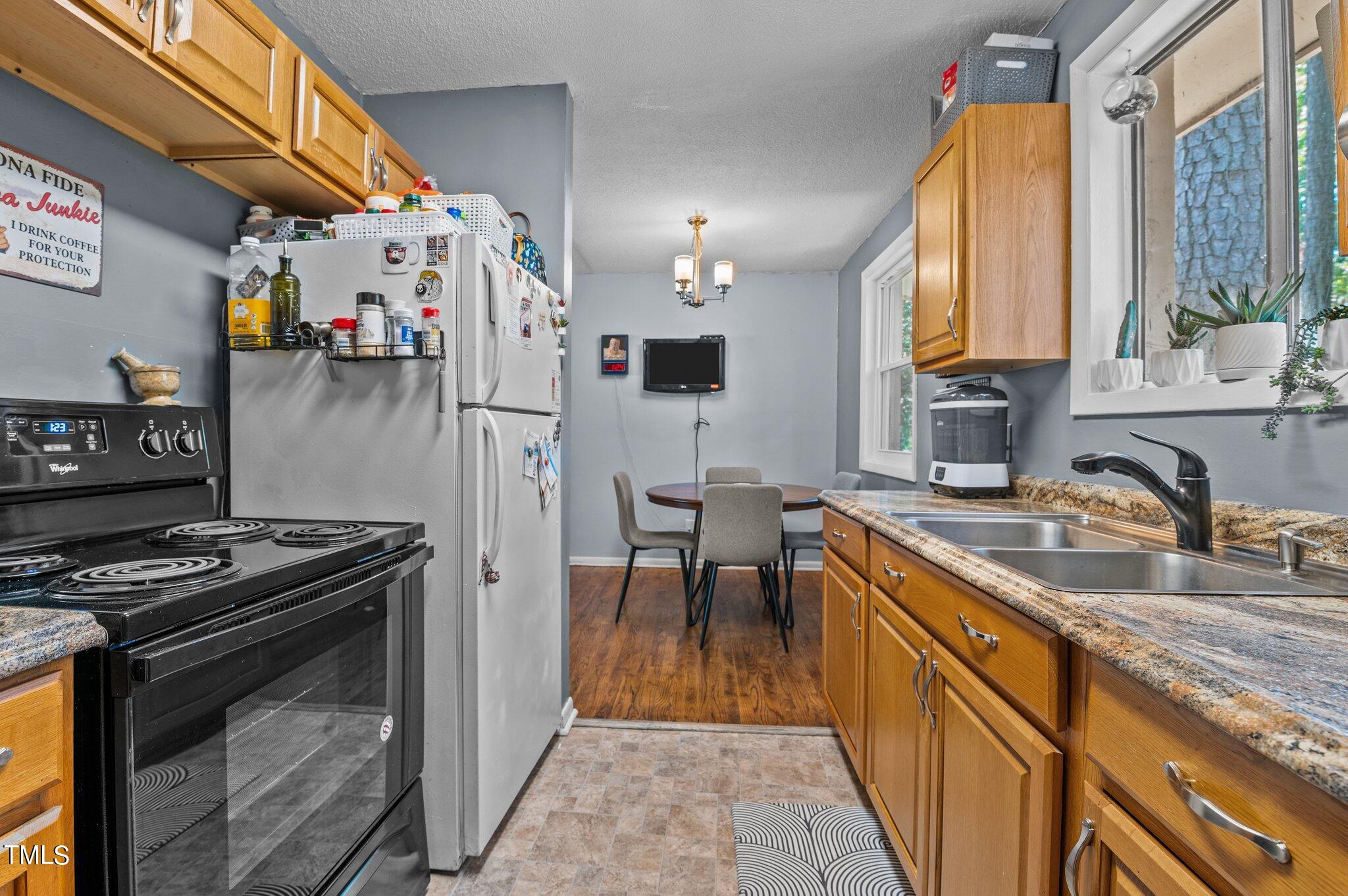 1708 Tee Dee Street Raleigh, NC 27610 - Photo 8 of 16 a kitchen with stainless steel appliances granite countertop a stove a sink and a microwave