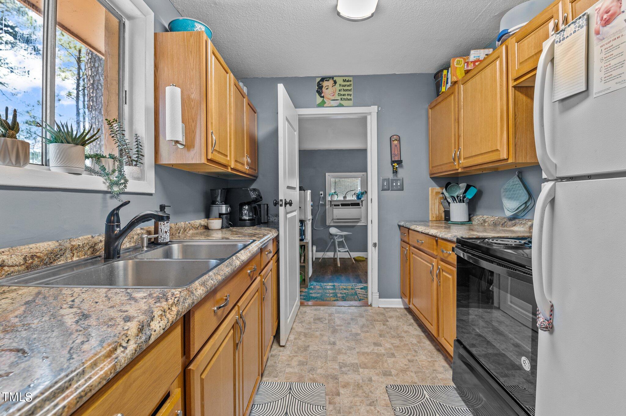 1708 Tee Dee Street Raleigh, NC 27610 - Photo 9 of 16 a kitchen with stainless steel appliances granite countertop a sink and a stove