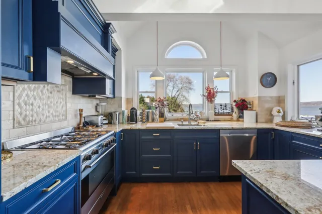 a kitchen with stainless steel appliances granite countertop a stove a sink dishwasher and cabinets with wooden floor