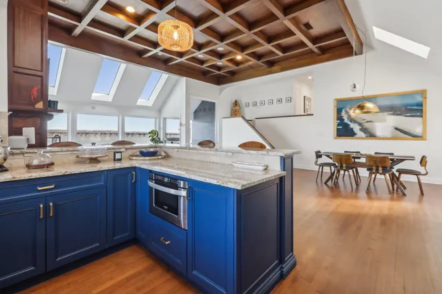 a kitchen with stainless steel appliances granite countertop a stove and a wooden floors