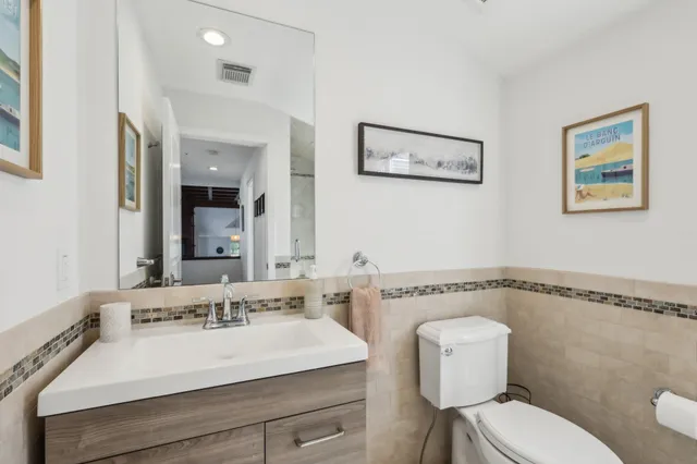 a bathroom with a sink mirror vanity and toilet