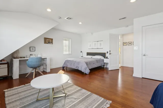 a bedroom with furniture and a wooden floor