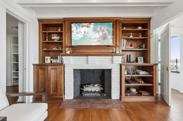 a living room with hard wood floors and a fireplace