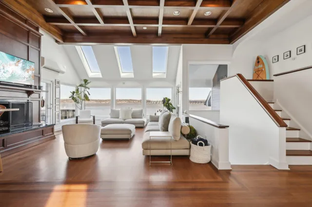 a living room with couches and a large mirror with wooden floor