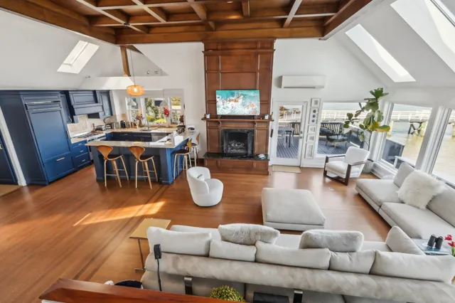 a living room with furniture a fireplace and kitchen view