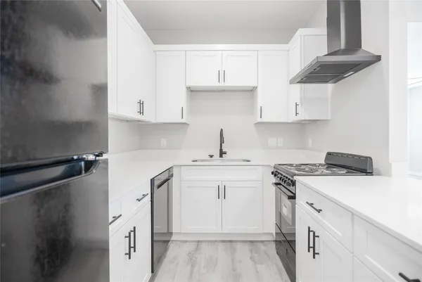 a kitchen with cabinets appliances a sink and a counter top