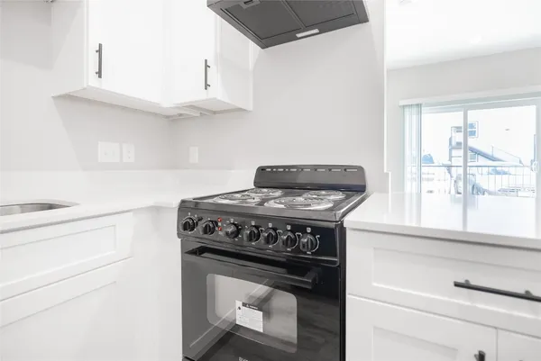 a stove top oven sitting inside of a kitchen