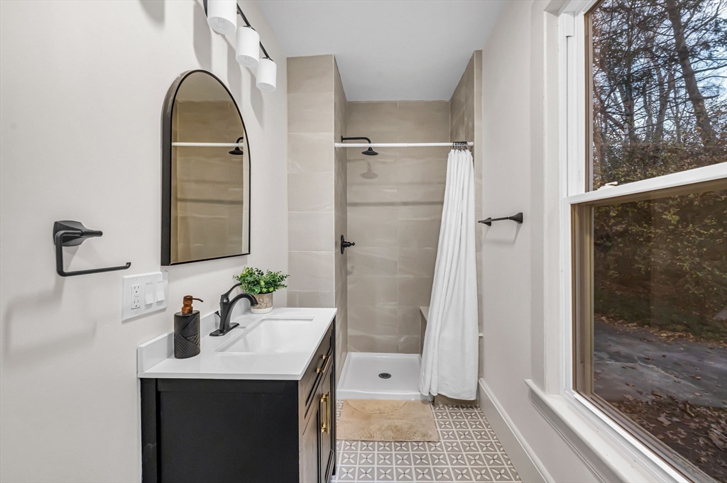 48 Gray Street Amherst, MA 01002 - Photo 13 of 42 a bathroom with a sink a mirror and a shower