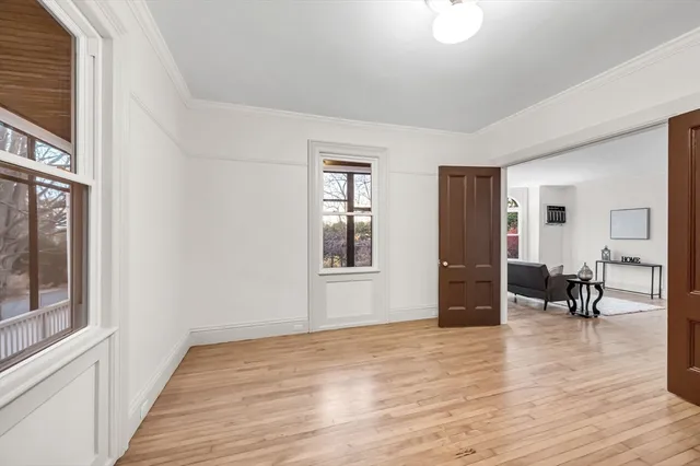 a view of empty room with wooden floor and furniture