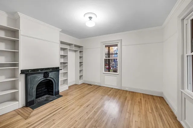 wooden floor fireplace and windows in an empty room