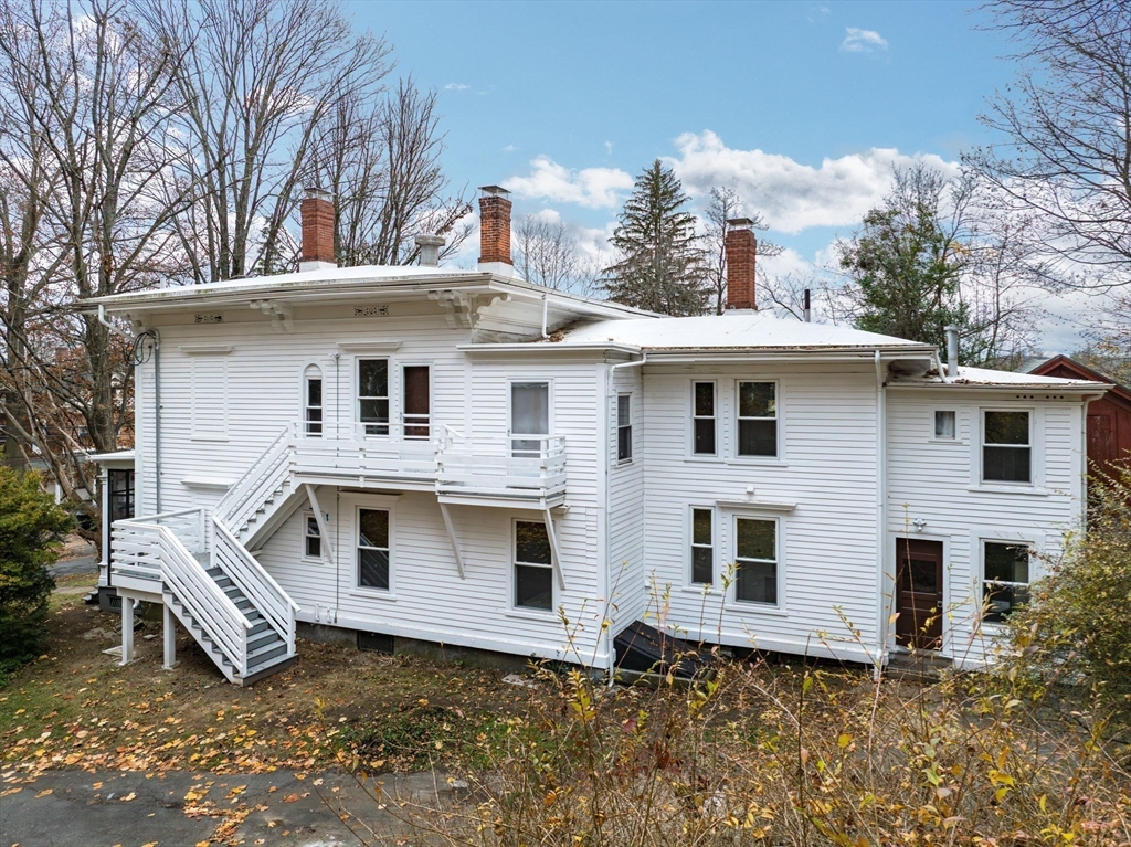 48 Gray Street Amherst, MA 01002 - Photo 34 of 42 a view of a white house with large windows and a tree