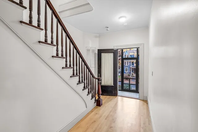 a view of staircase with wooden floor and white walls
