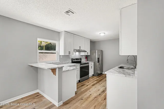a kitchen with a sink stove and refrigerator