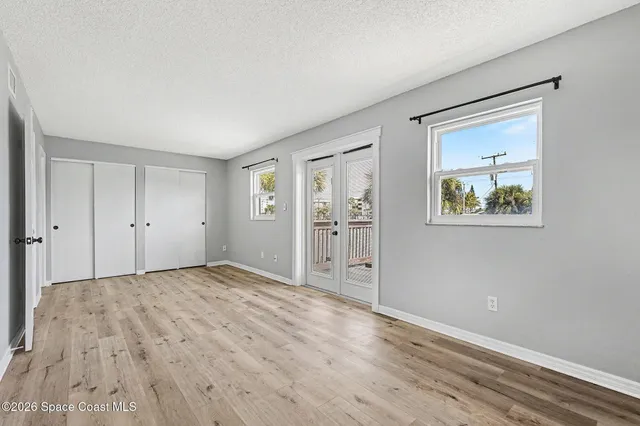 a view of an empty room with wooden floor