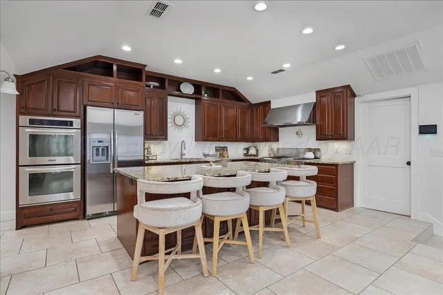 a kitchen with granite countertop a sink dishwasher stove and cabinets
