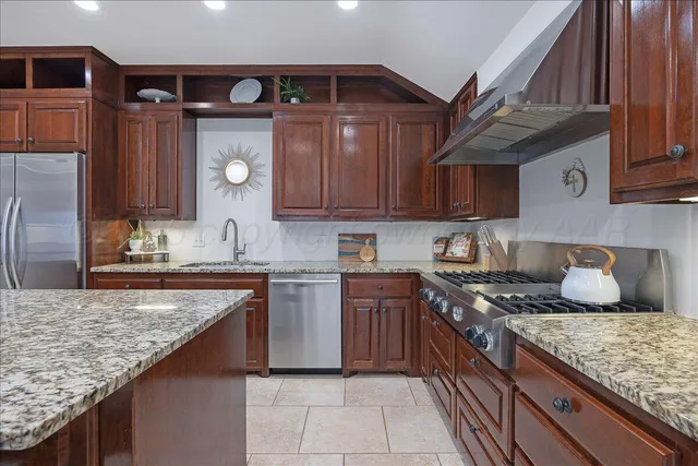 a kitchen with stainless steel appliances granite countertop a sink and a granite counter tops